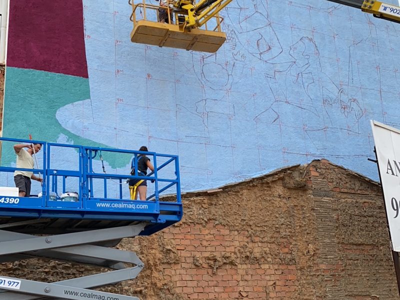 El artista Diego Vicente esta realizando un mural inspirado en el conocido carton para tapiz de Goya La vendimia 1 e1631528999410